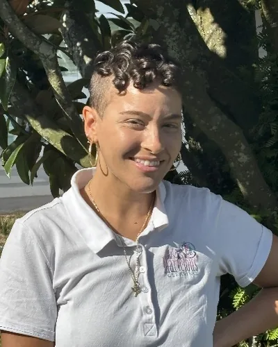 Angie McCoy smiling outdoors in a white Mrs. Marvelous Cleaning polo.