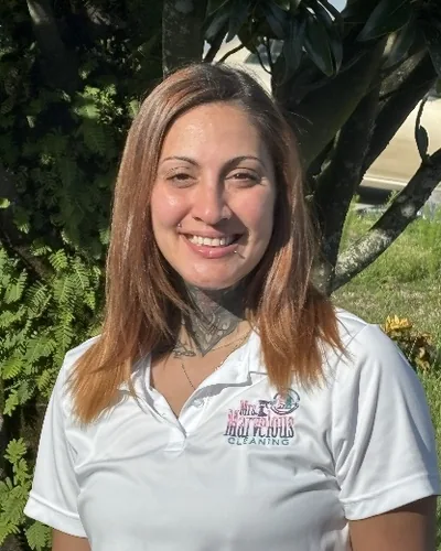Sheila Orozco smiling in the sun in a white Mrs. Marvelous Cleaning polo.