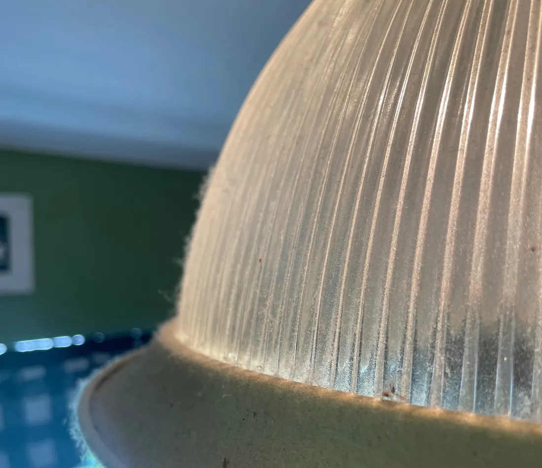 Before: A ribbed glass light fixture furred with dust.