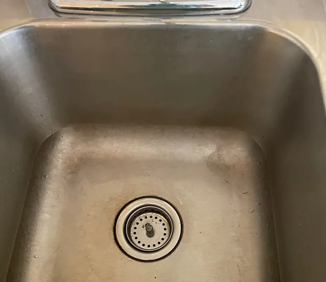 Before: A dull, water-spotted stainless steel sink.
