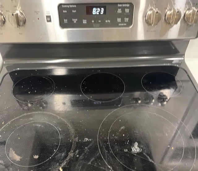 Before: A glass stovetop covered in burnt-on spills.